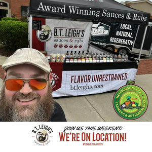 B.T. Leigh's Sauces and Rubs vendor booth at Hendersonville Farmers & Artisan Market with smiling bearded man.